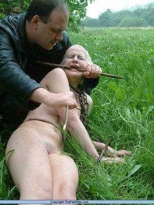 Naked blonde slave is caned and stomped on in a field of lush grass on justmyfans.pics